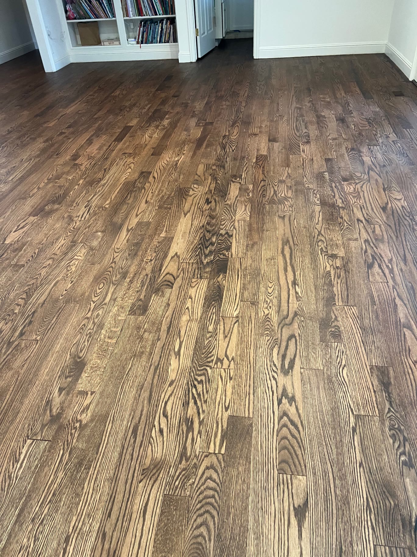 Open room with newly installed and stained oak flooring