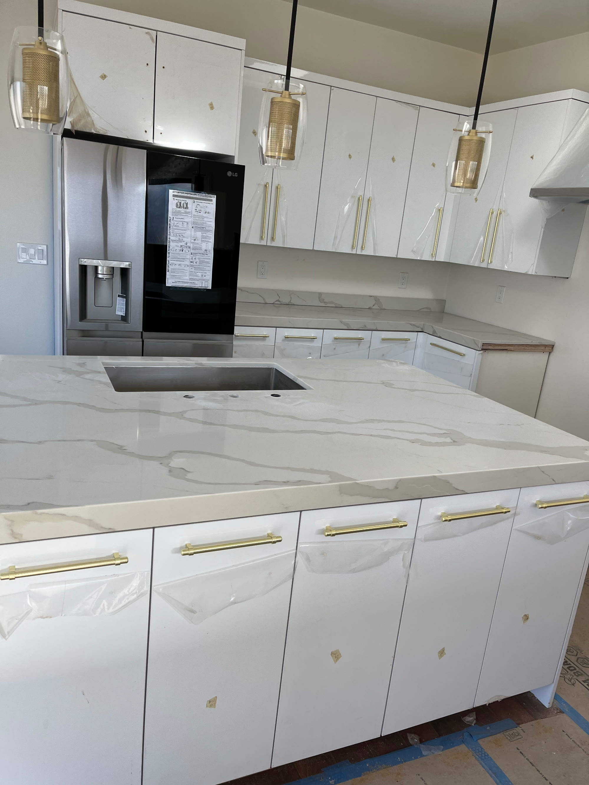 Perimeter counter run in veined quartz with gold cabinet pulls