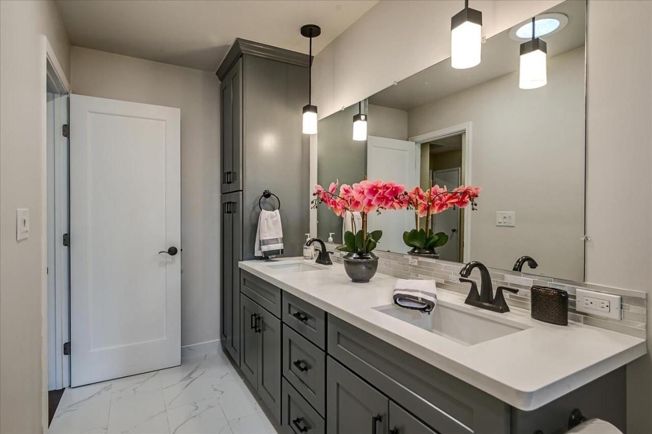 Gray shaker double vanity with quartz counter, mosaic backsplash and glass pendants