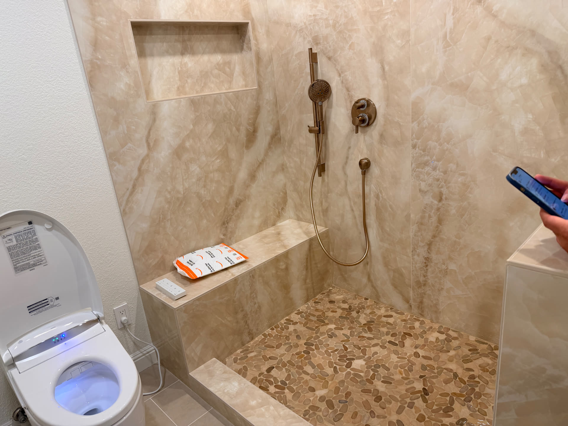 Shower bench and recessed niche in onyx-look porcelain with bronze fixtures