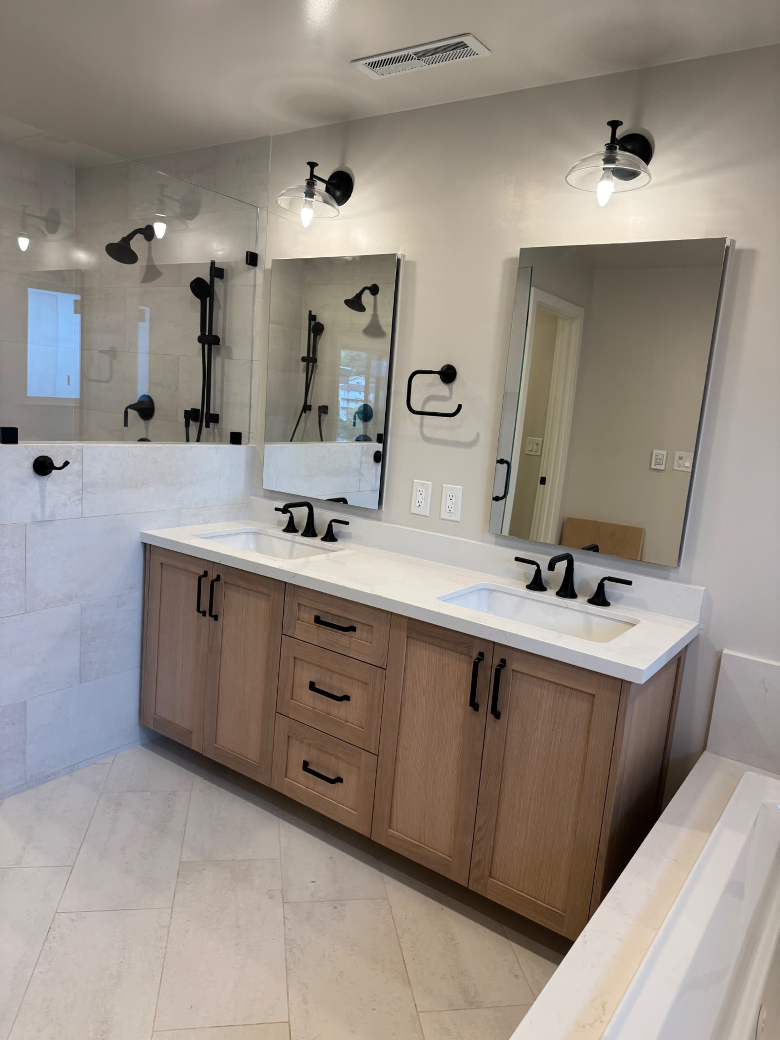 White oak double vanity with quartz counter and matte black fixtures