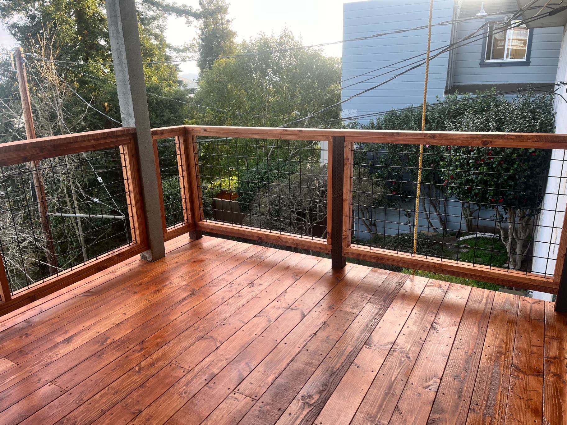 Corner of the lower deck with redwood railing and garden beyond