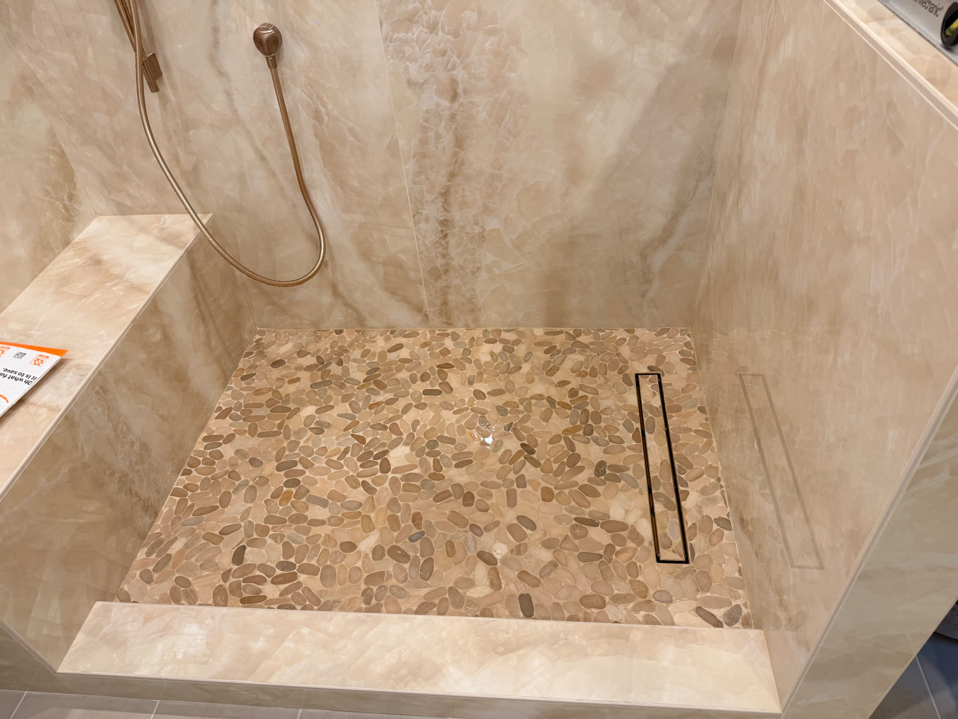 Shower pan with river pebble floor and linear drain