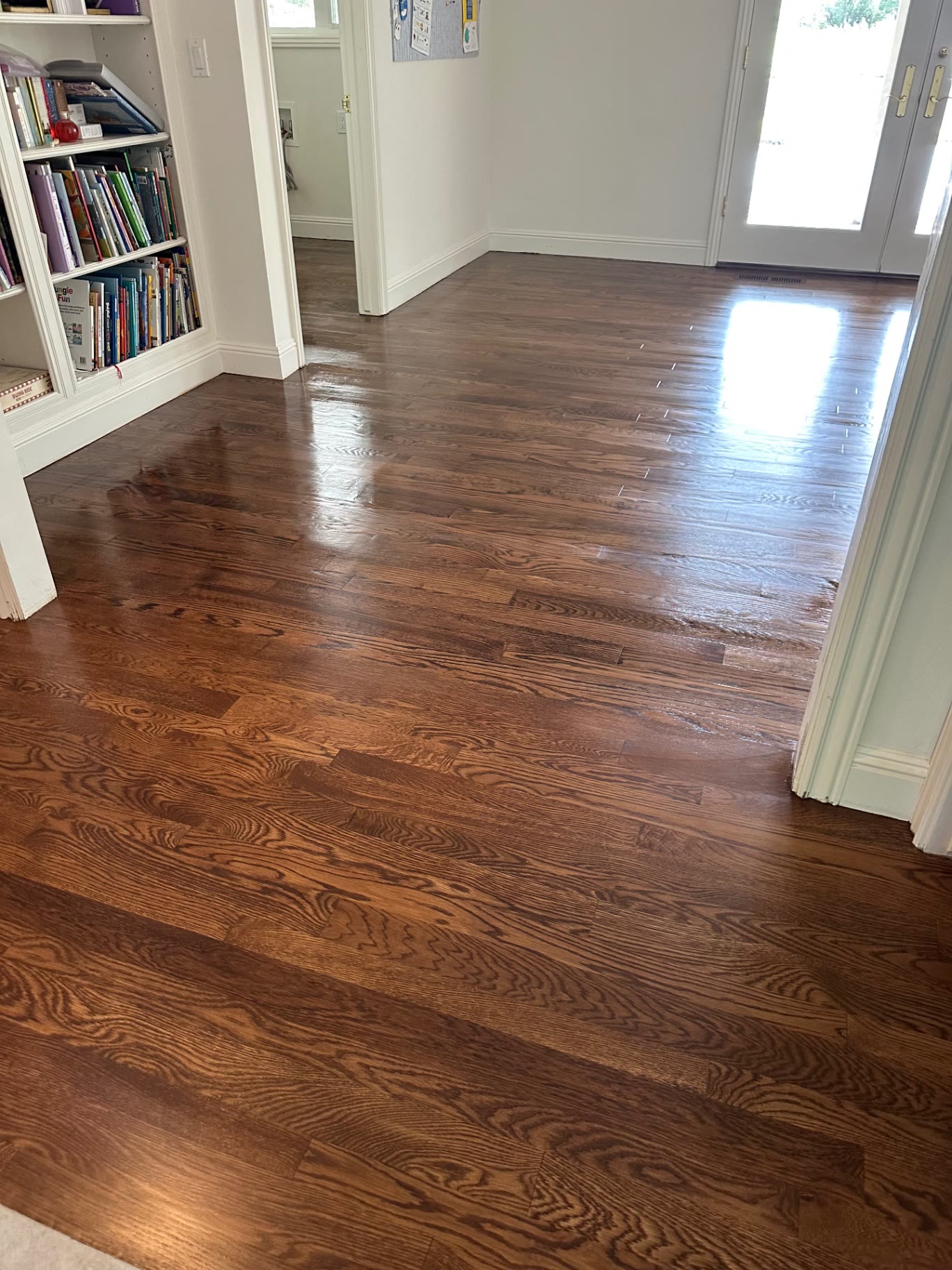 Red oak flooring running from the living room into the hallway