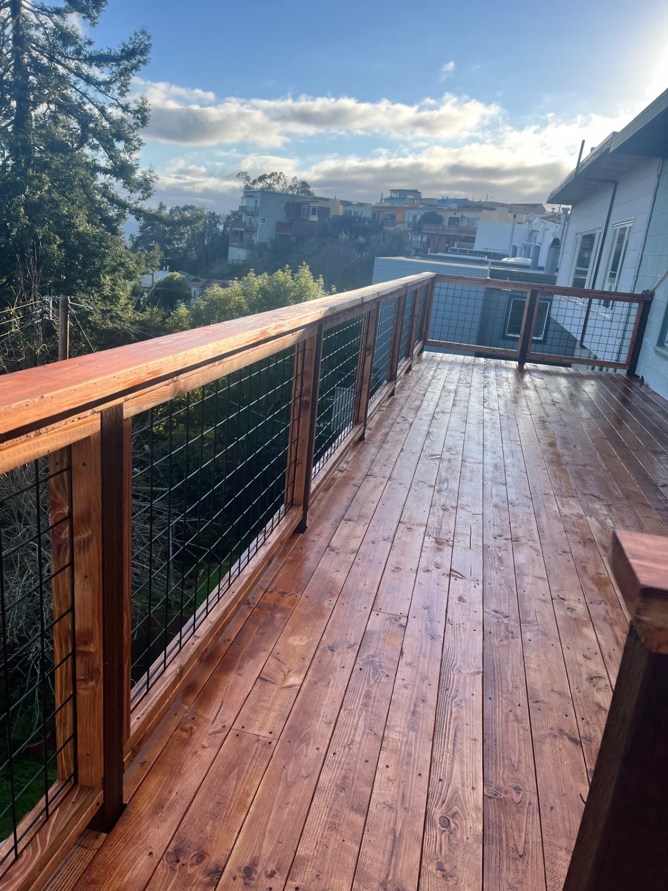Redwood railing with black welded wire infill along the deck edge